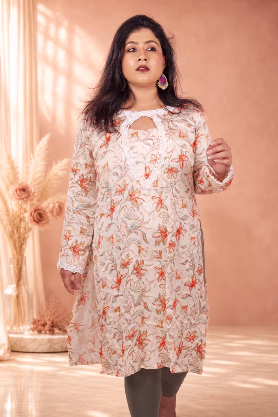 Full-length front view of a model wearing a premium cream floral silk kurti, highlighting its graceful straight fit and peach floral print.