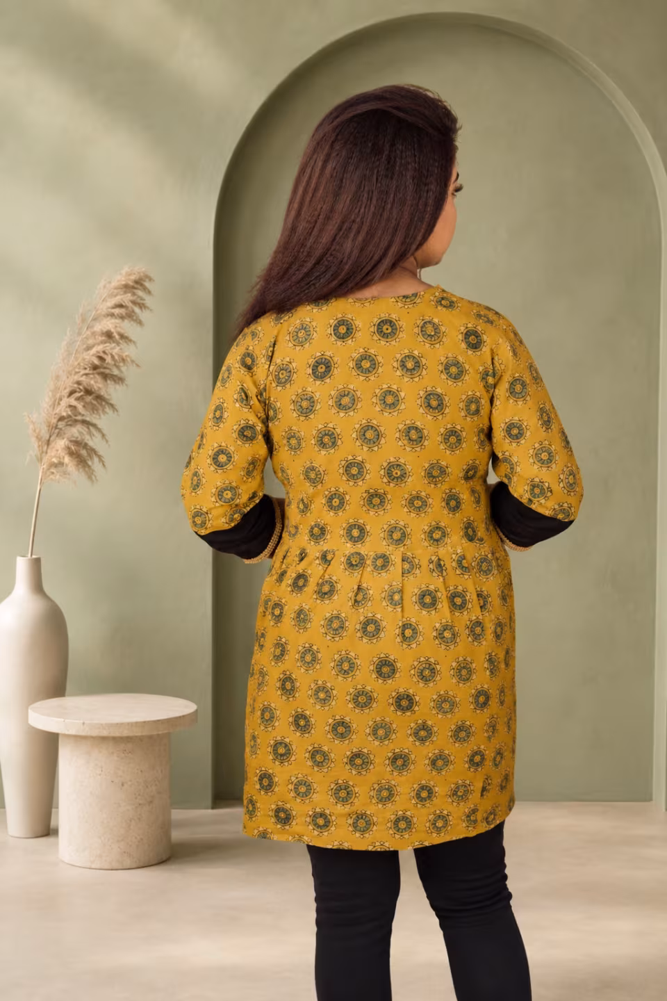 Back view of mustard Bagru block print A-line kurti showing full print coverage and black contrast sleeves
