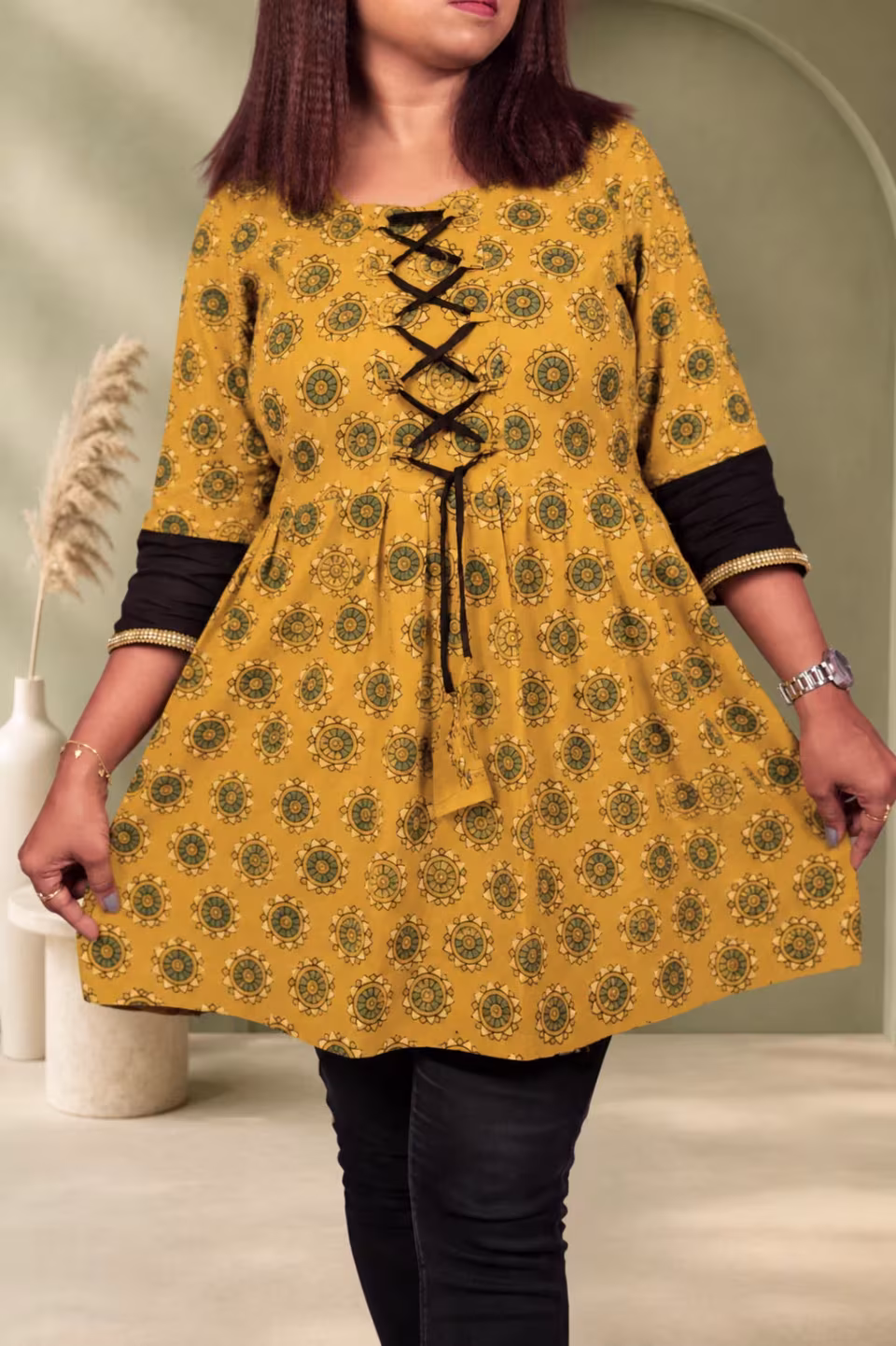 Side profile view of mustard Bagru block print A-line kurti showing flared silhouette and black sleeve