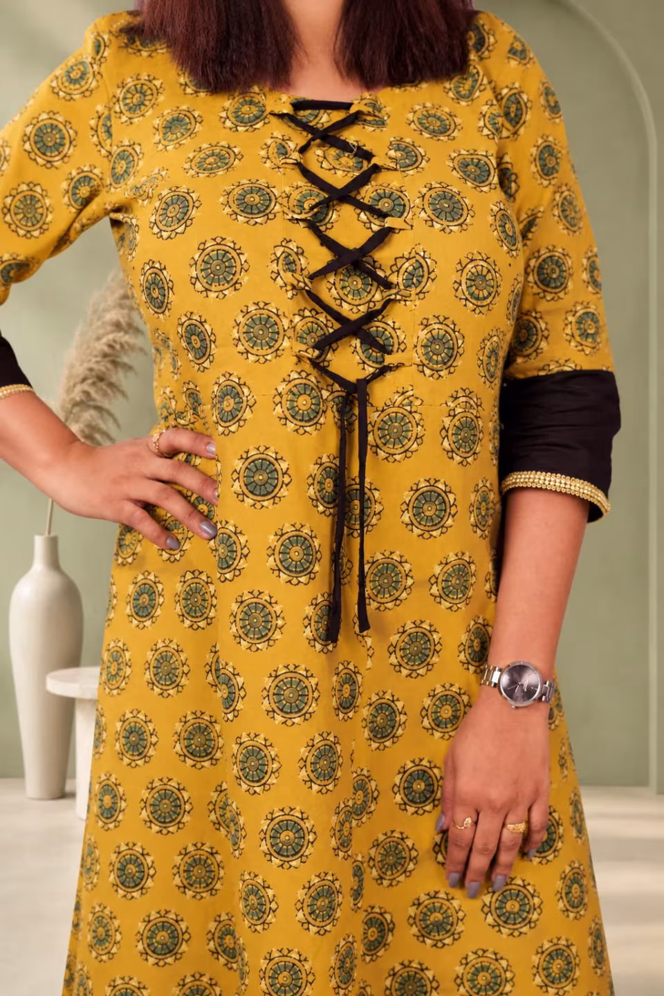 Upper body front detail of mustard Bagru block print kurti with black lace-up and contrast sleeve