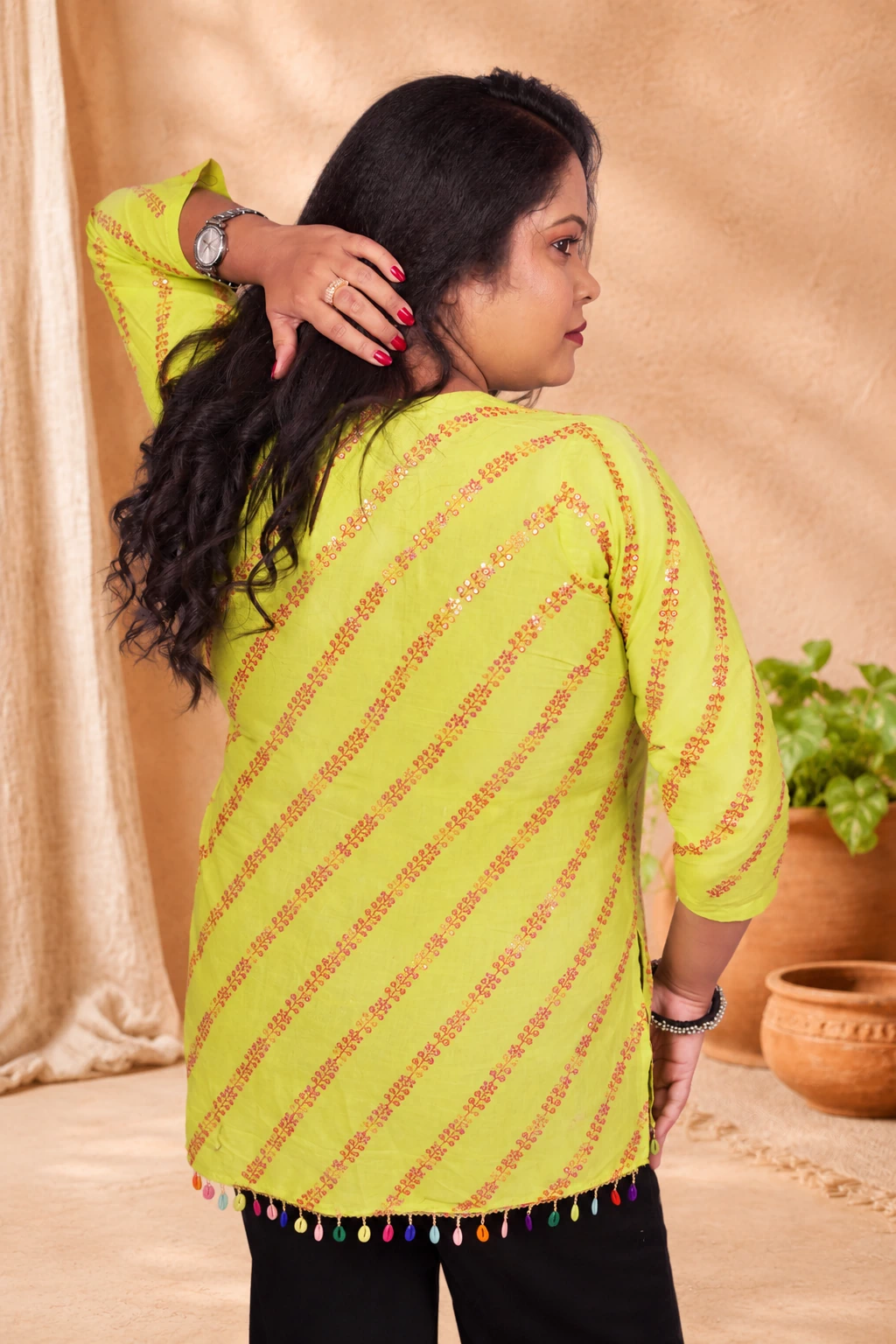 Back view of lime green cotton kurti with sequin stripe print and tassel hem